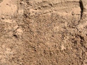 A pile of sand is sitting on top of a pile of dirt.