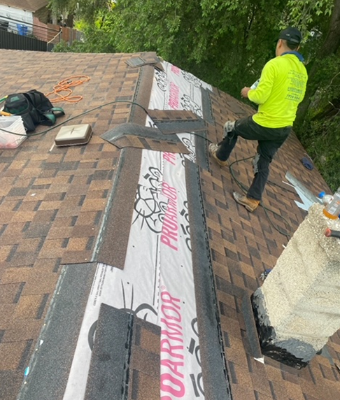 a man in a neon shirt is working on a roof