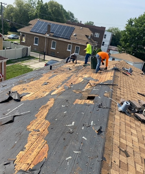 two men are working on the roof of a house