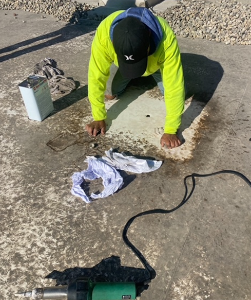 a man wearing a hurley hat is working on a concrete surface