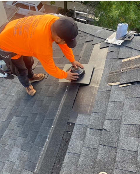 a man in an orange shirt is working on a roof