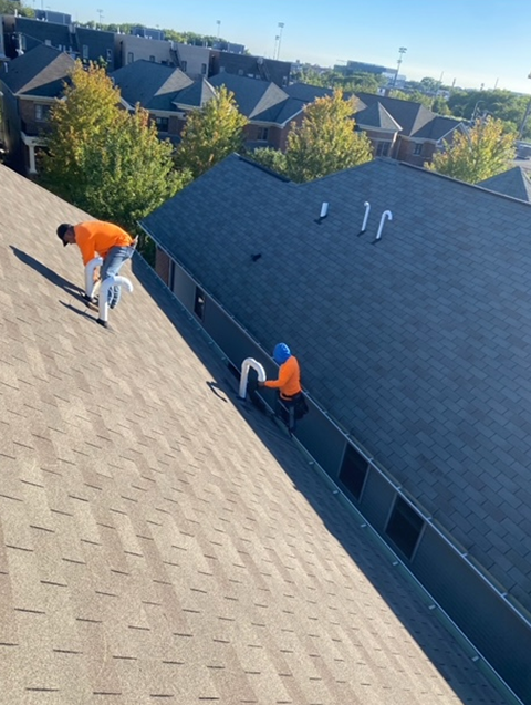 two men are working on the roof of a house