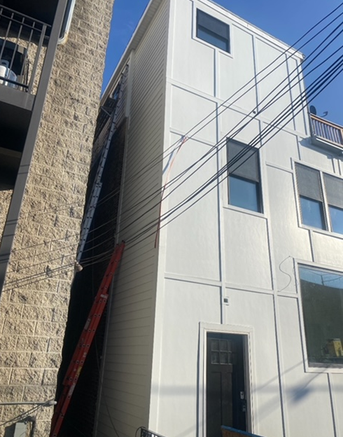 a white building with a red ladder in front of it