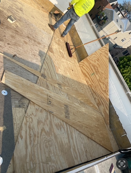 a man is standing on a roof with a broom