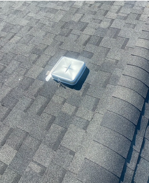 a white box with a cross on top of a roof