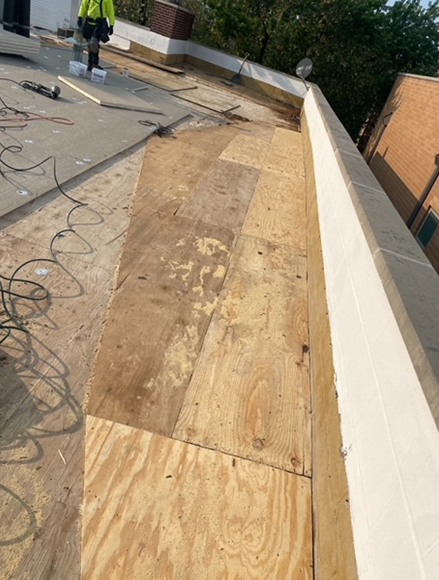a roof with a lot of plywood on it is being repaired .