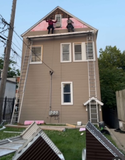 two men are working on the roof of a house