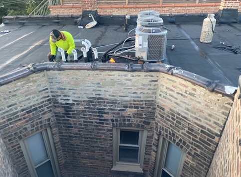 a man is working on the roof of a building