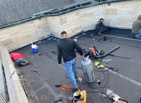 a group of men are working on a roof