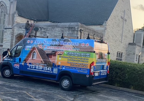a roofing company van is parked in front of a church