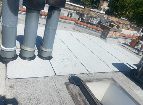 a roof with a skylight and pipes on it