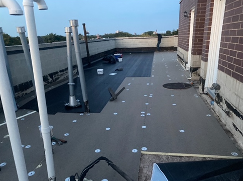 a roof is being installed on top of a brick building