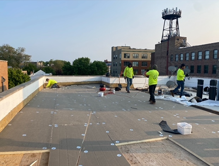 a group of people are working on the roof of a building