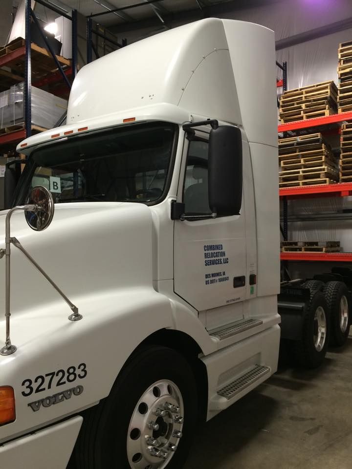 A white volvo semi truck is parked in a warehouse