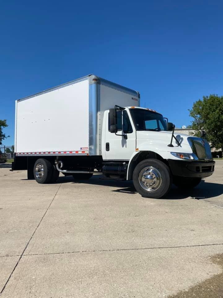A white box truck is parked in a parking lot.