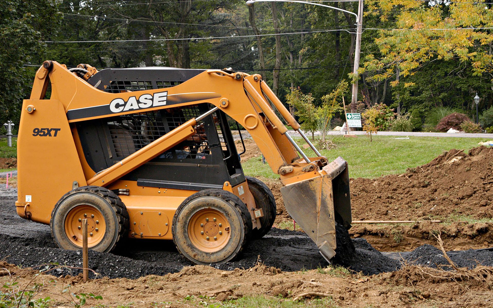 A case skid steer is digging a hole in the dirt