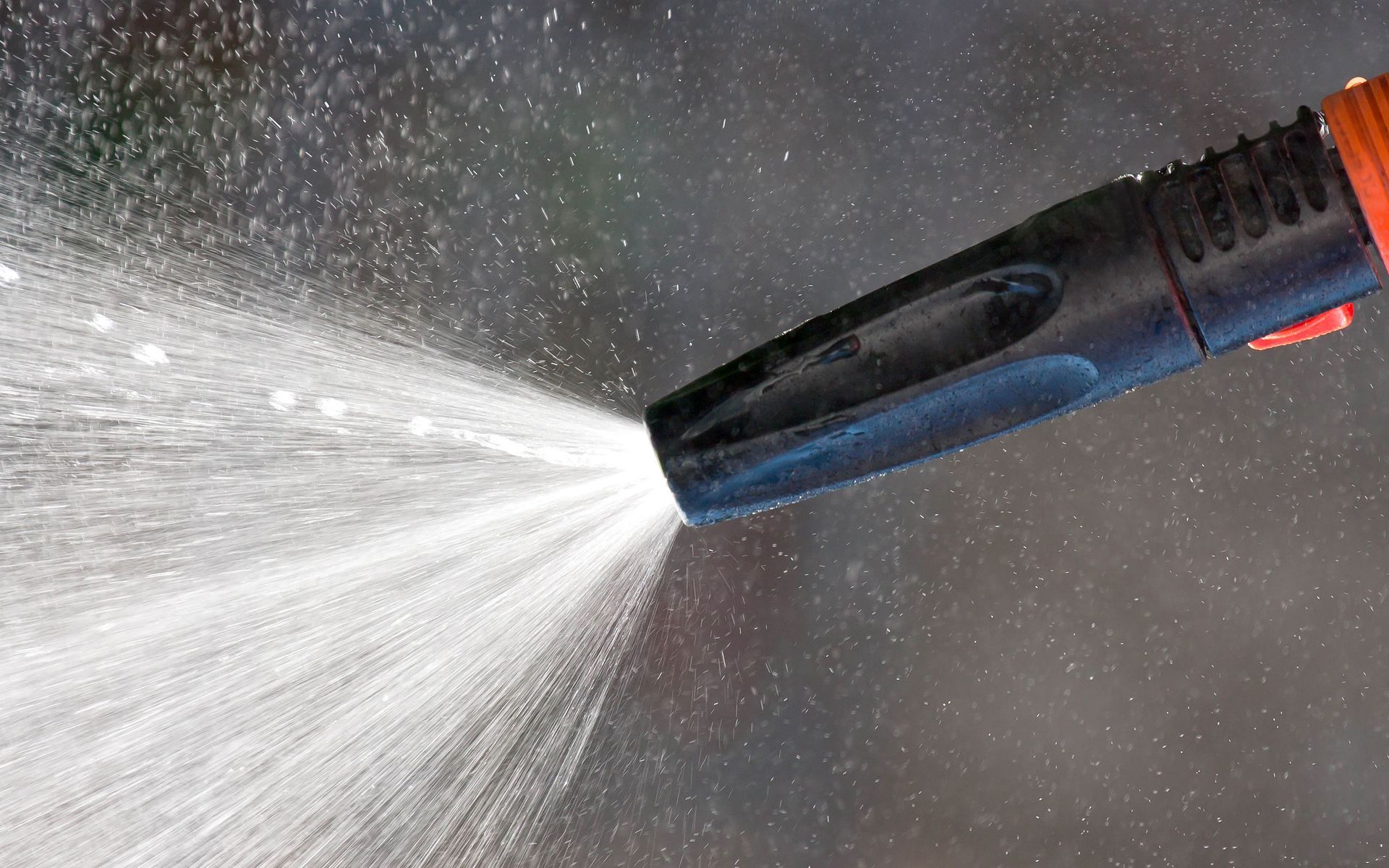 A close up of a high pressure washer spraying water.