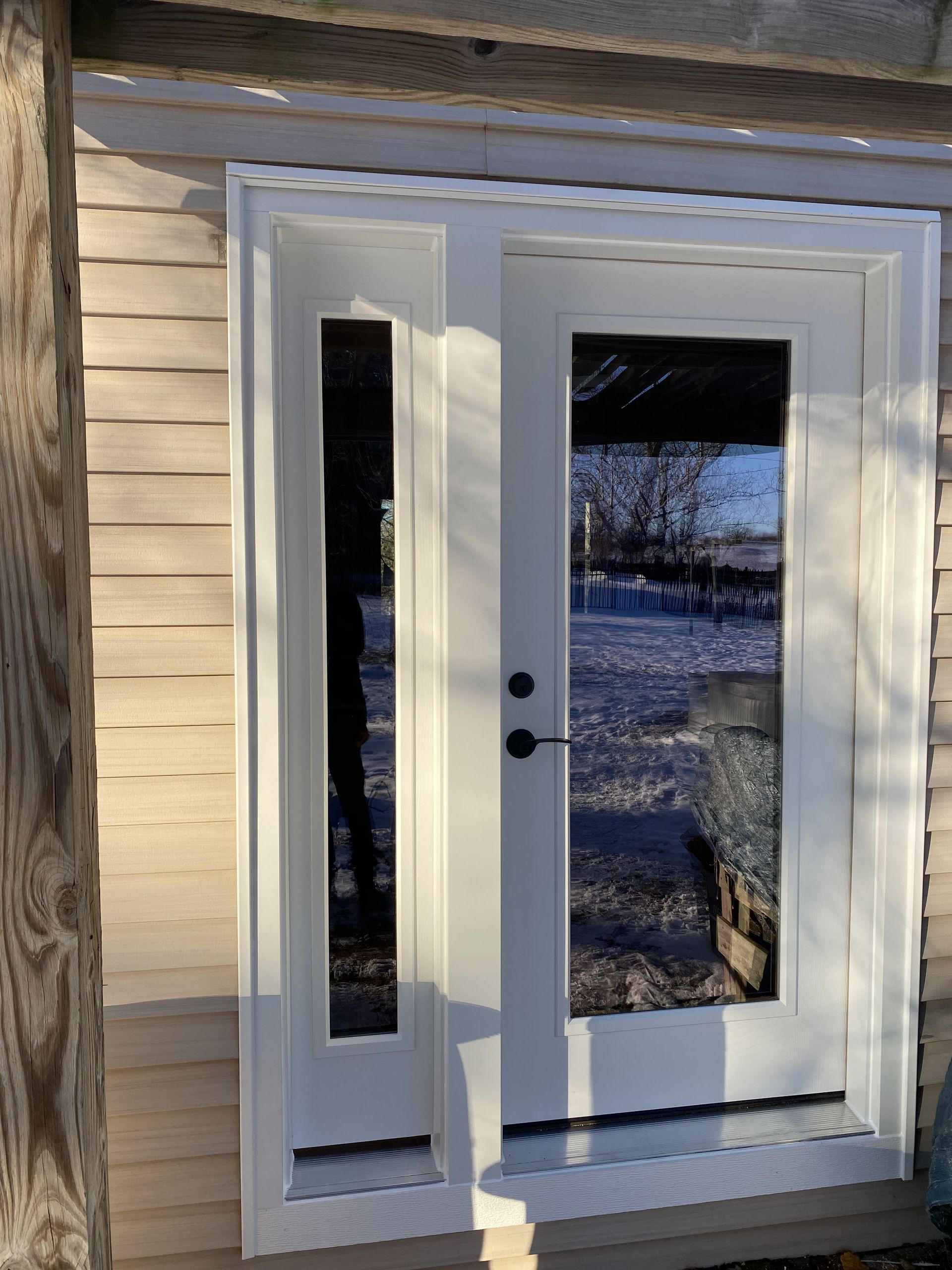 White double exterior door with glass panes on a house, viewed in daylight.