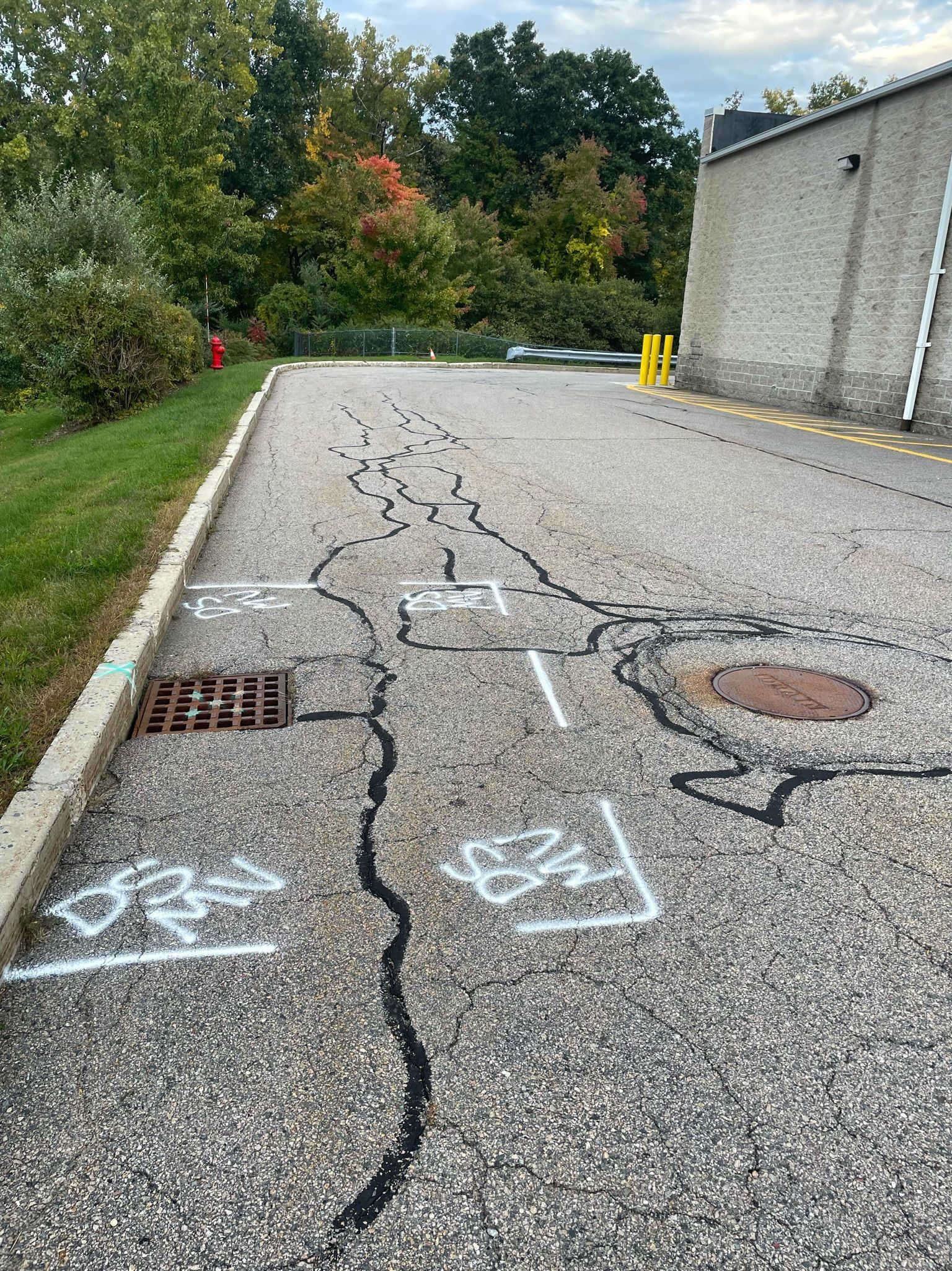 A road with graffiti on it and a building in the background.