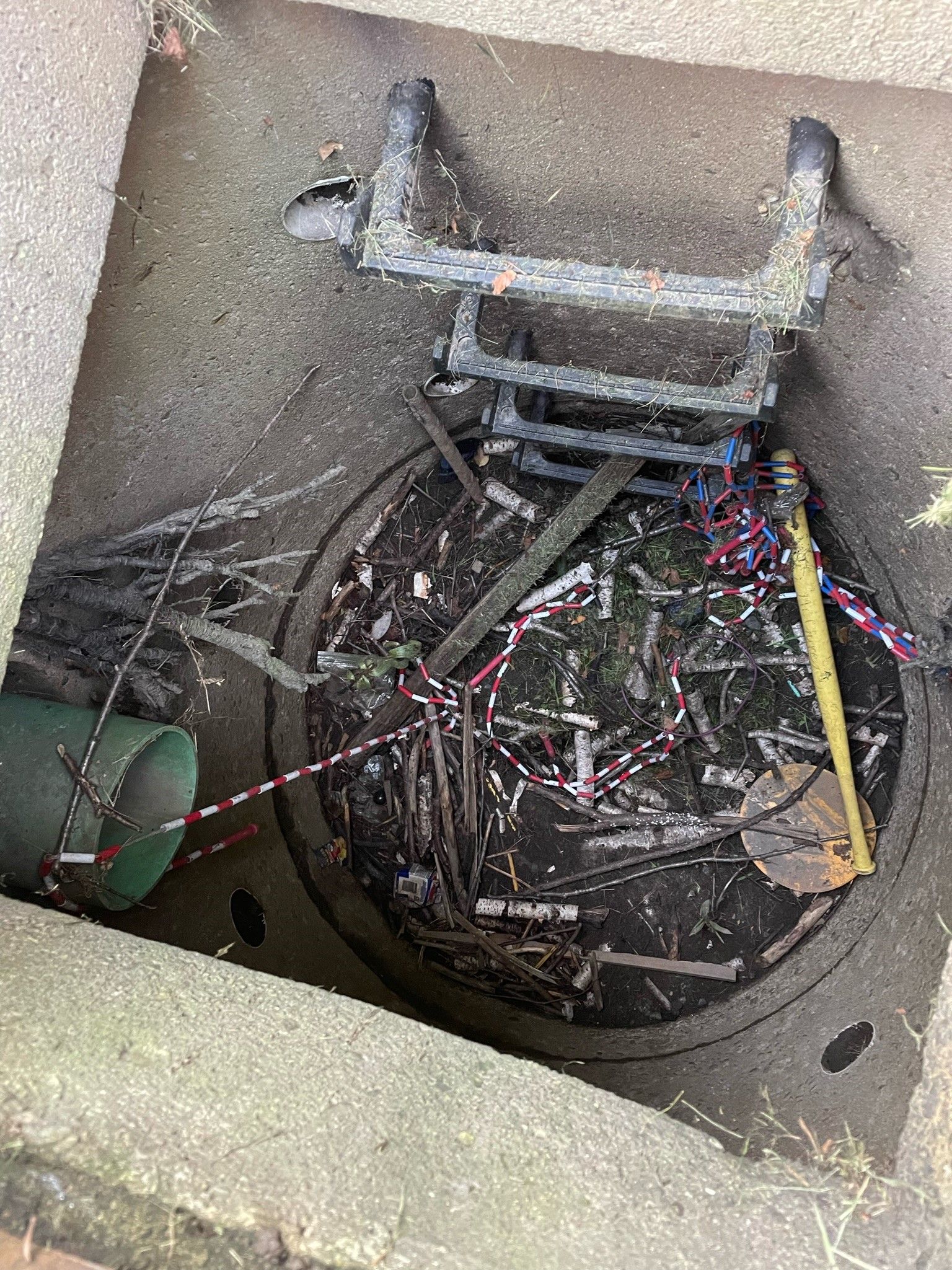 A manhole cover with a ladder sticking out of it.