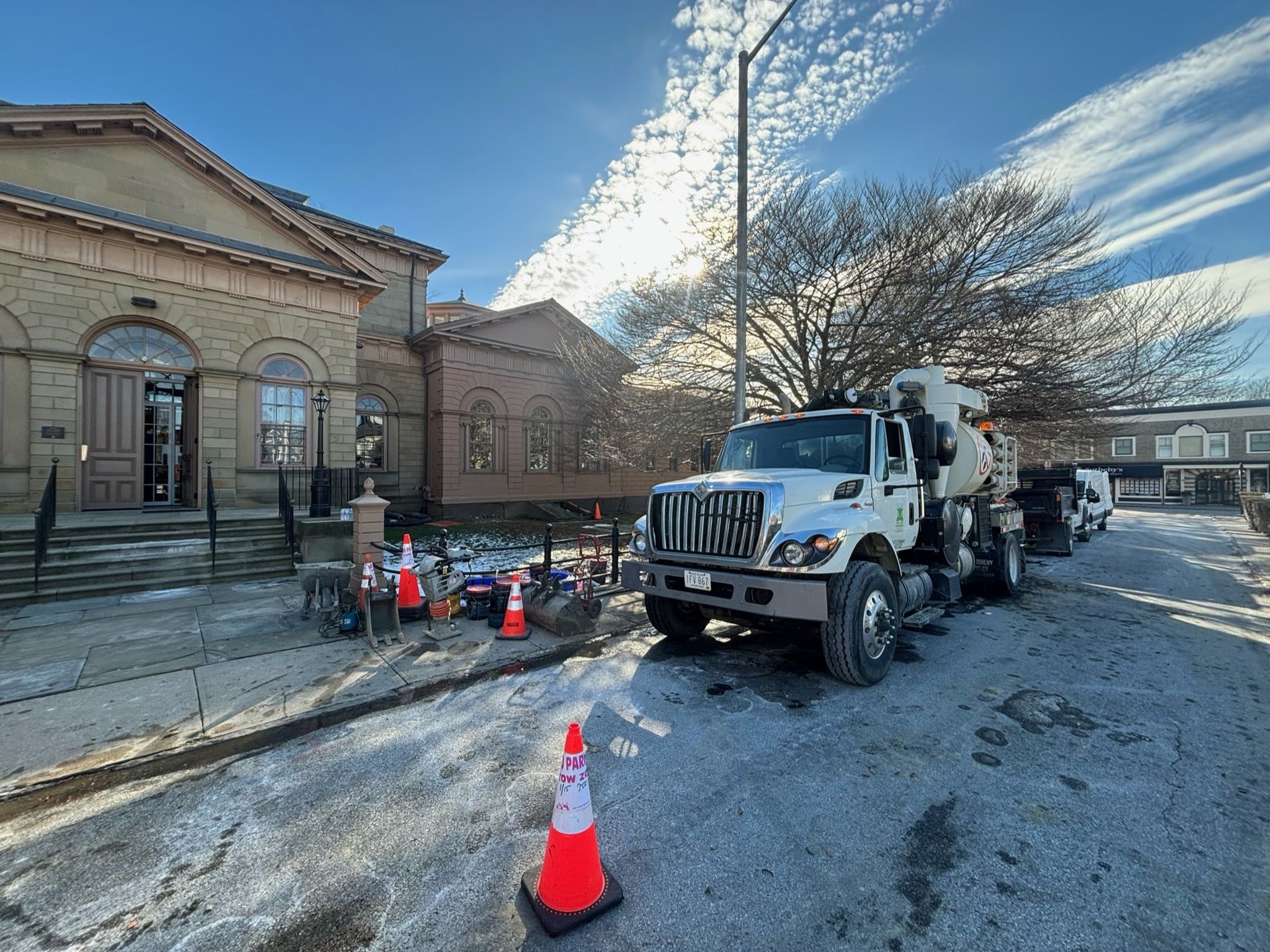 A truck is parked in the snow in front of a building.