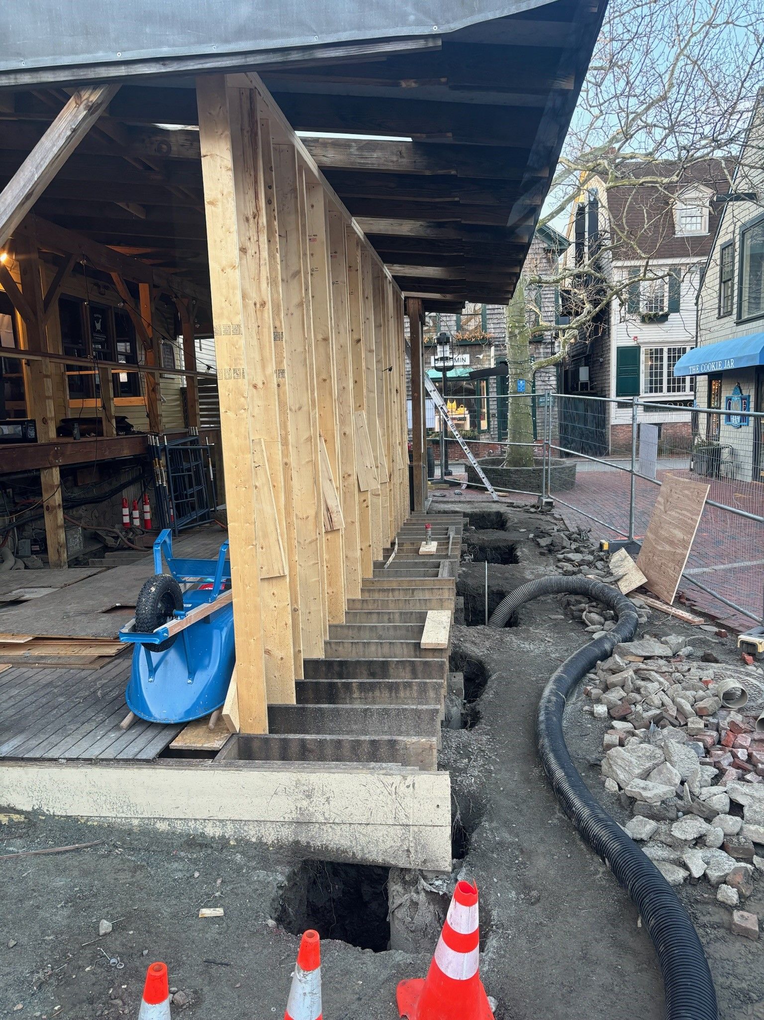 A building is being built in a city with a lot of cones in front of it.