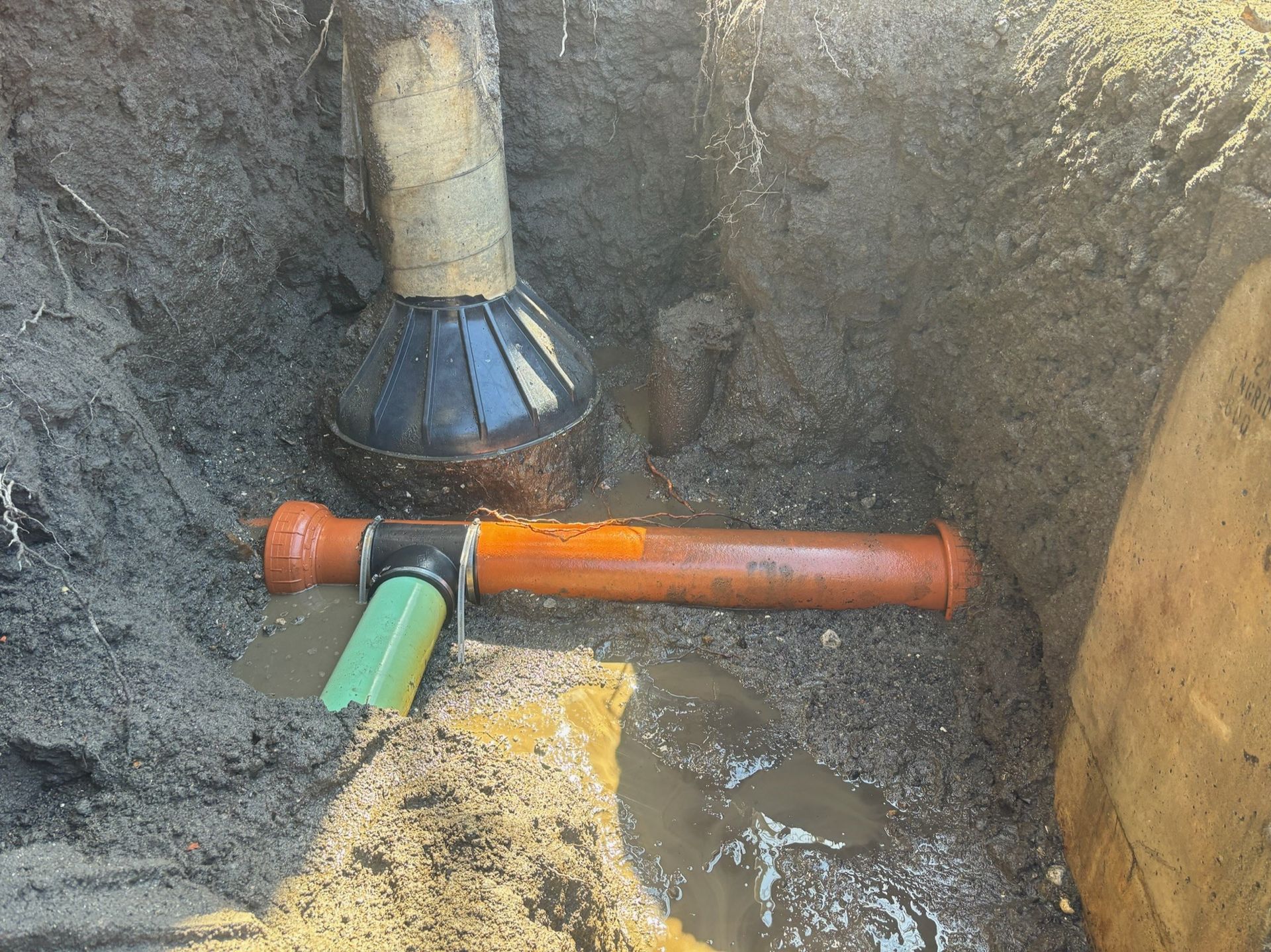 A pipe is being installed in a hole in the ground.