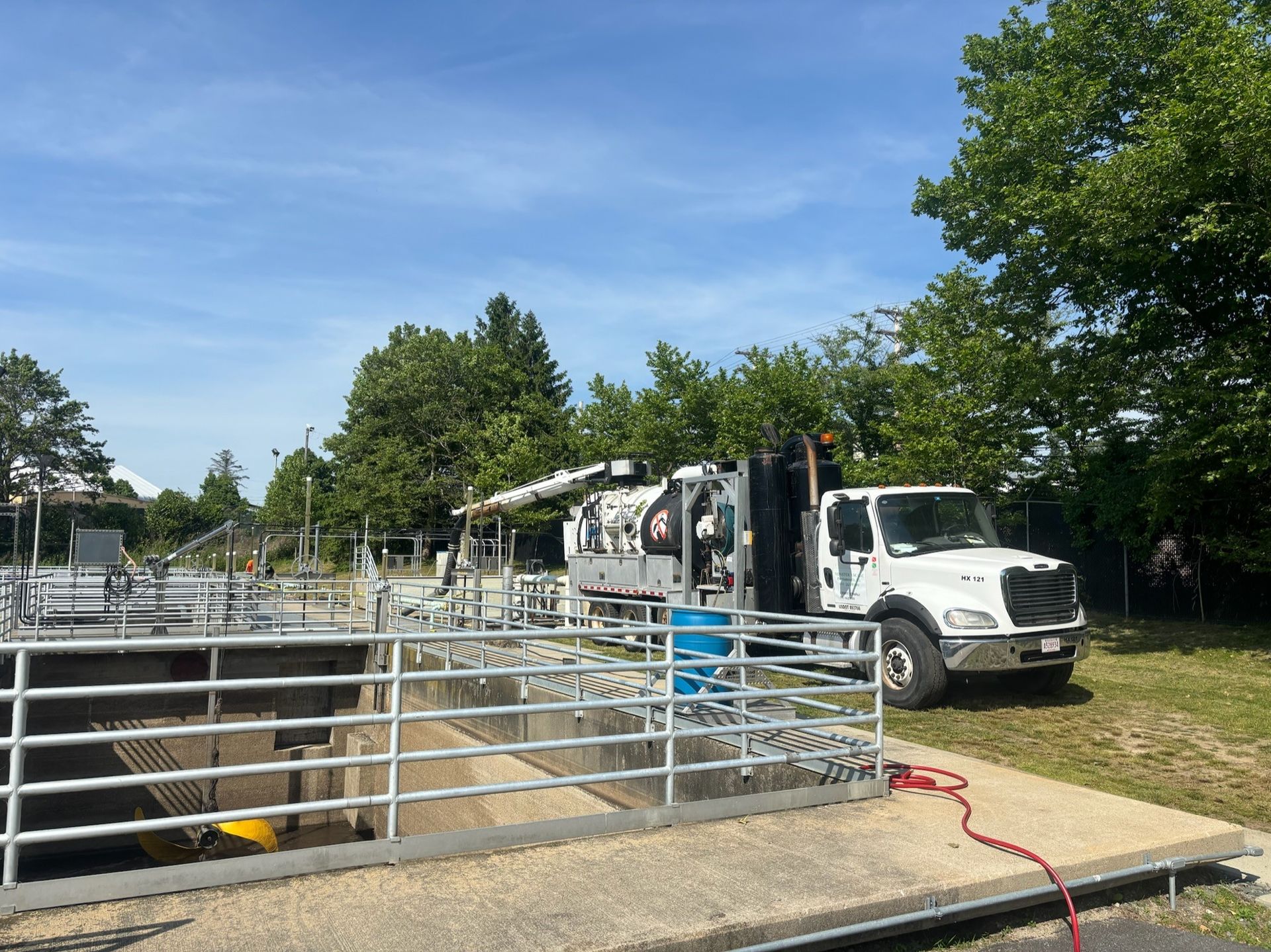 A white truck is parked next to a fence in a field.