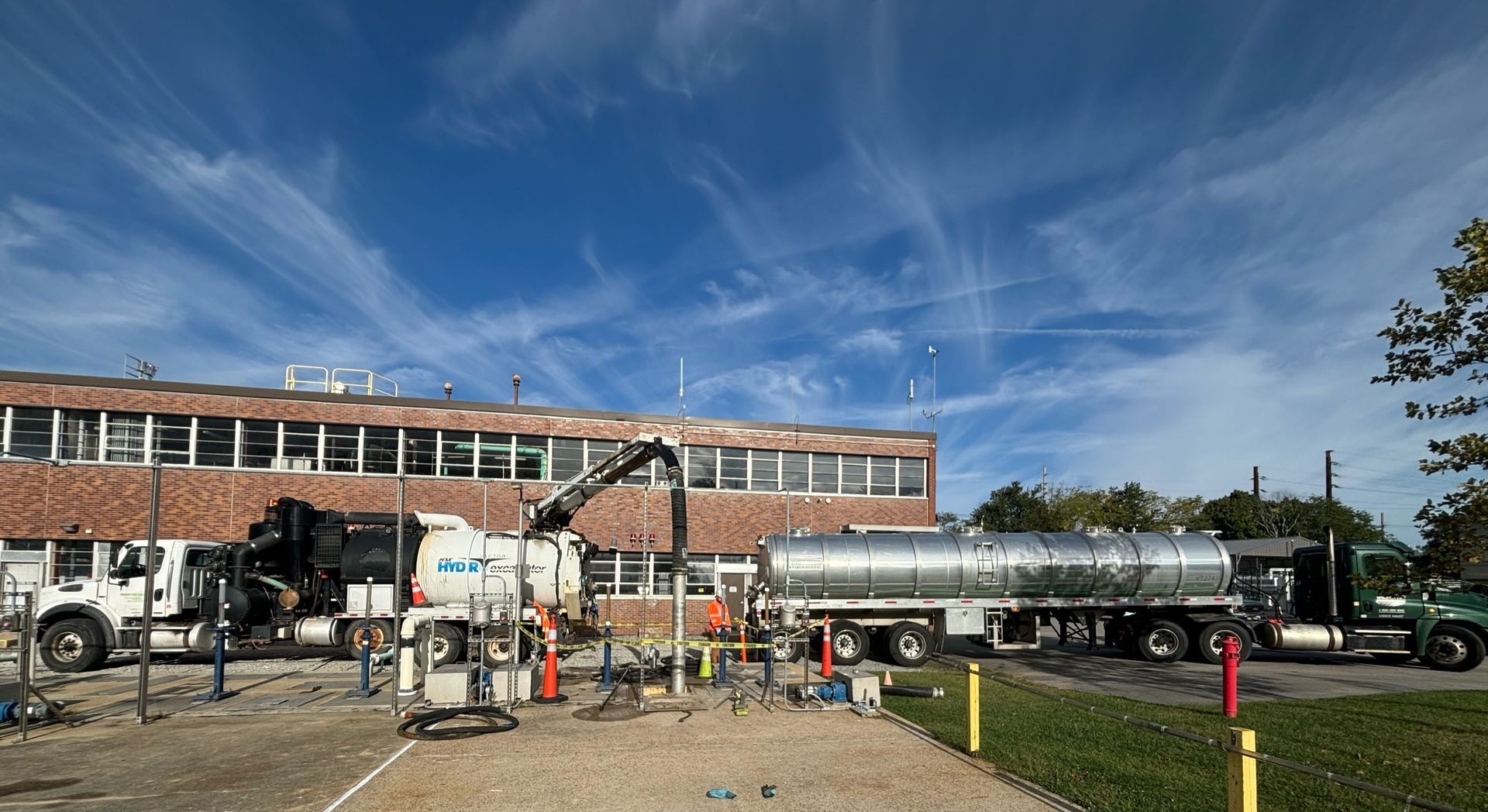A large tanker truck is parked in front of a brick building.