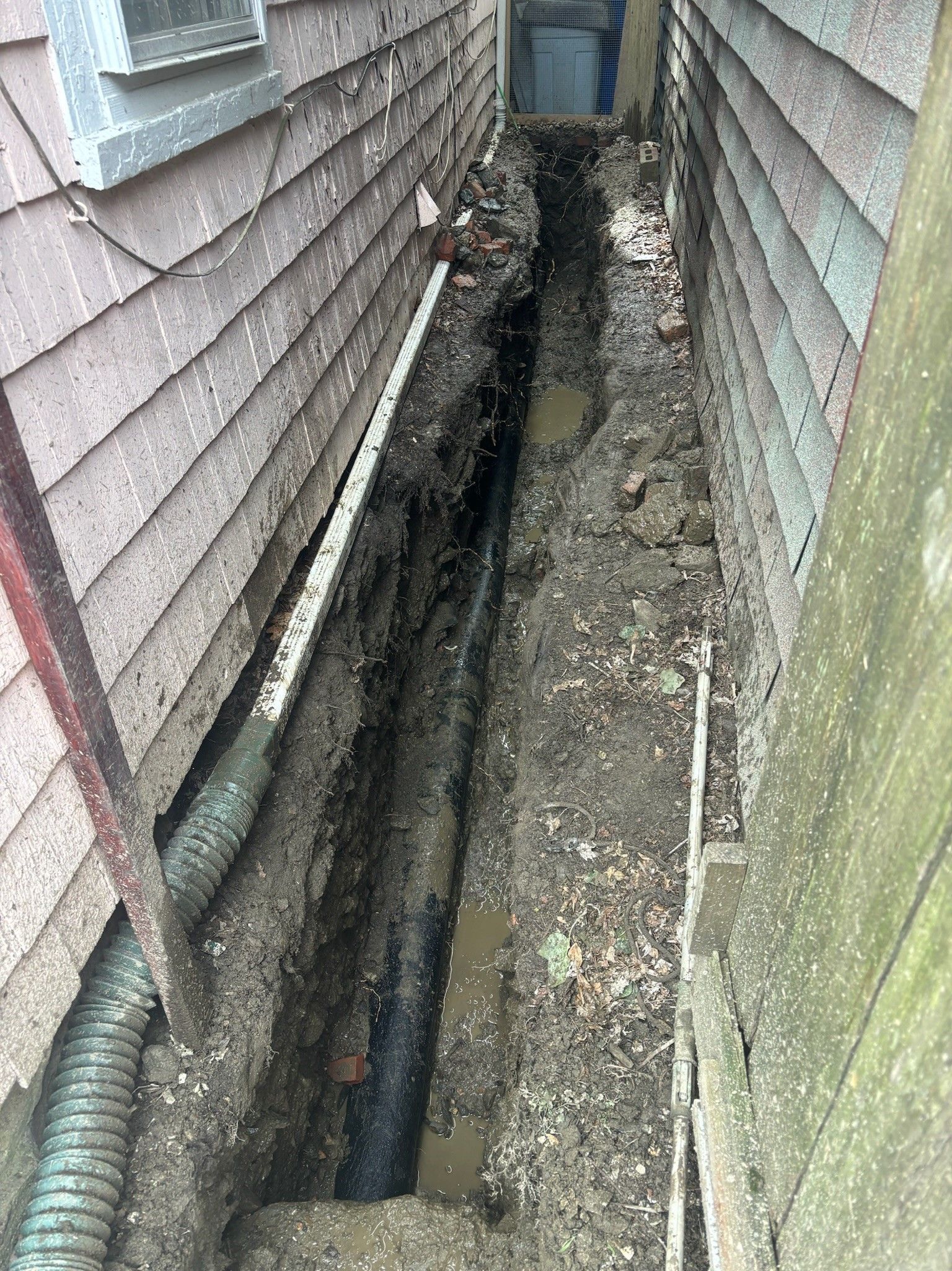 There is a hole in the ground next to a house.