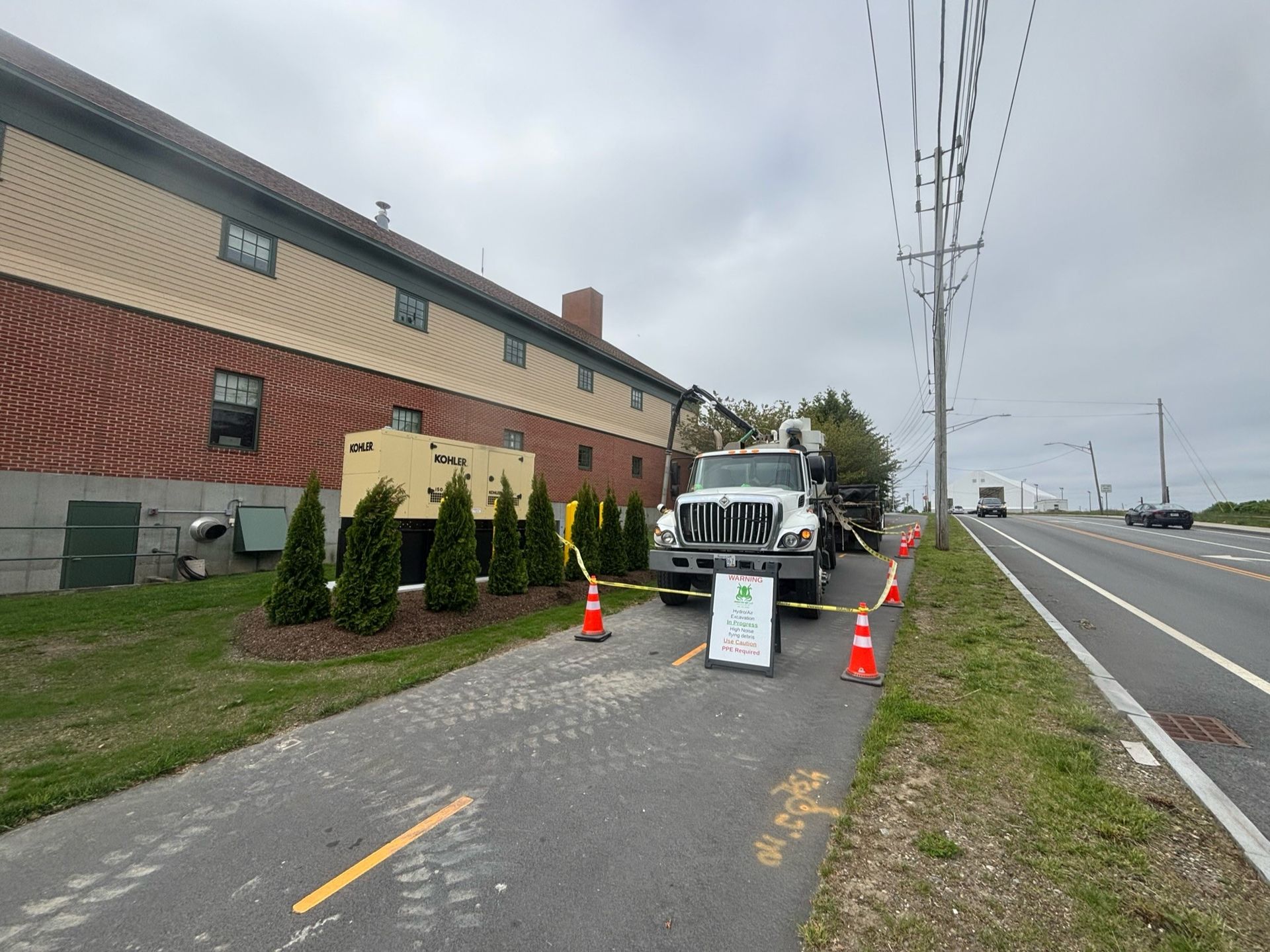 A truck is parked on the side of the road next to a building.