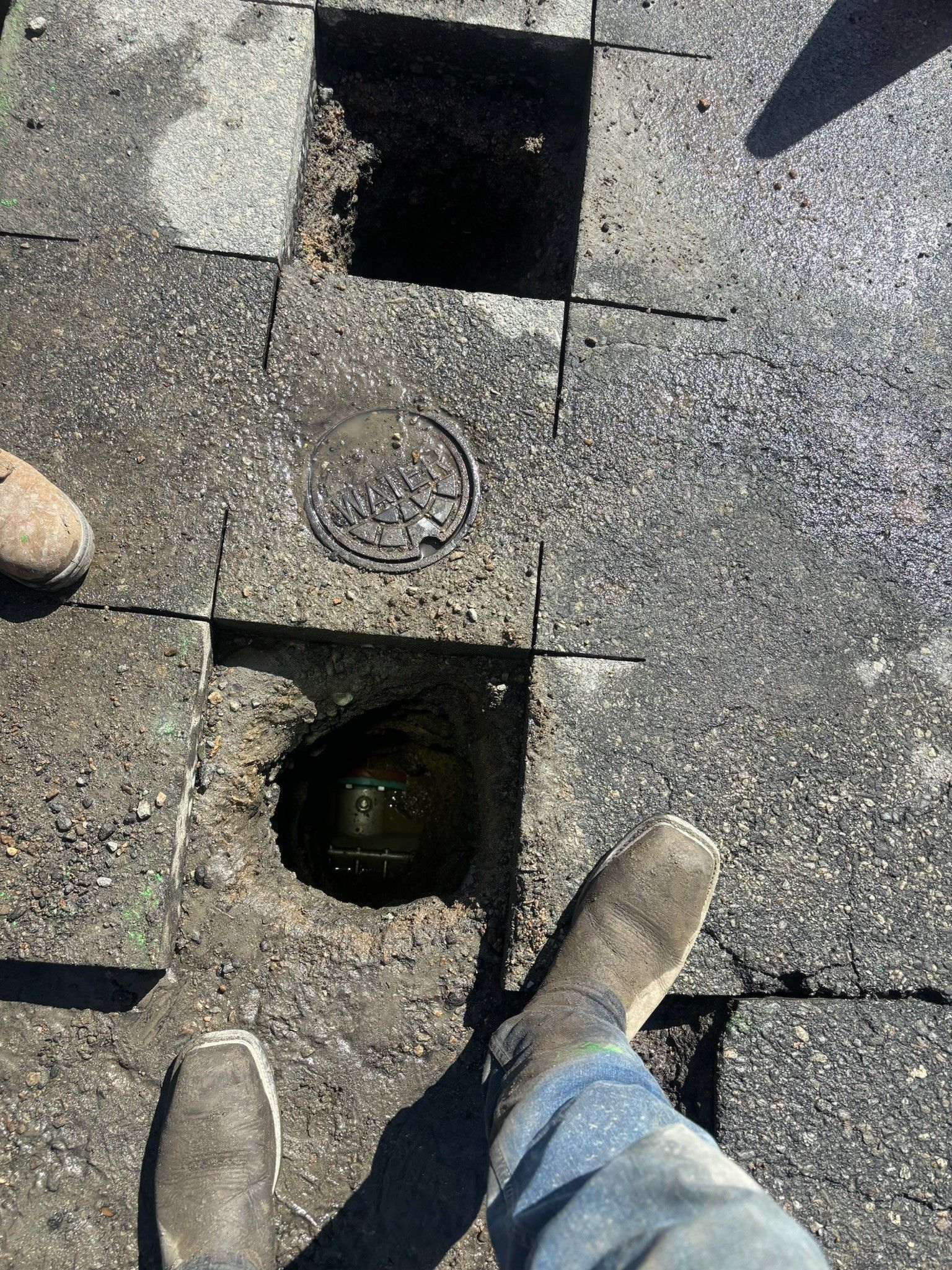 A person is standing next to a hole in the ground.