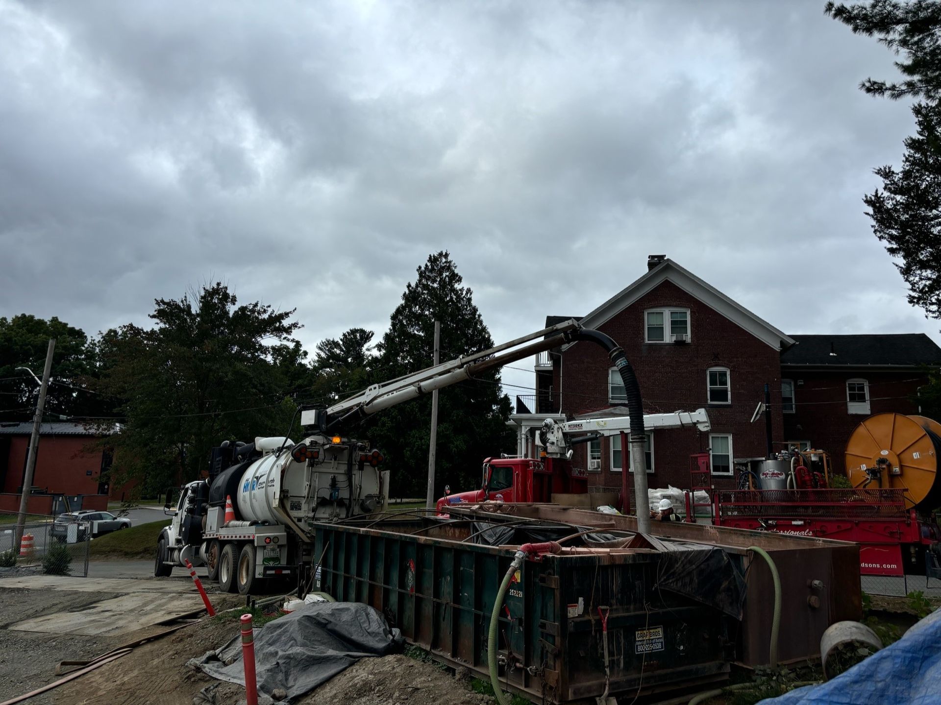 A concrete pump is being used to pump concrete into a large container