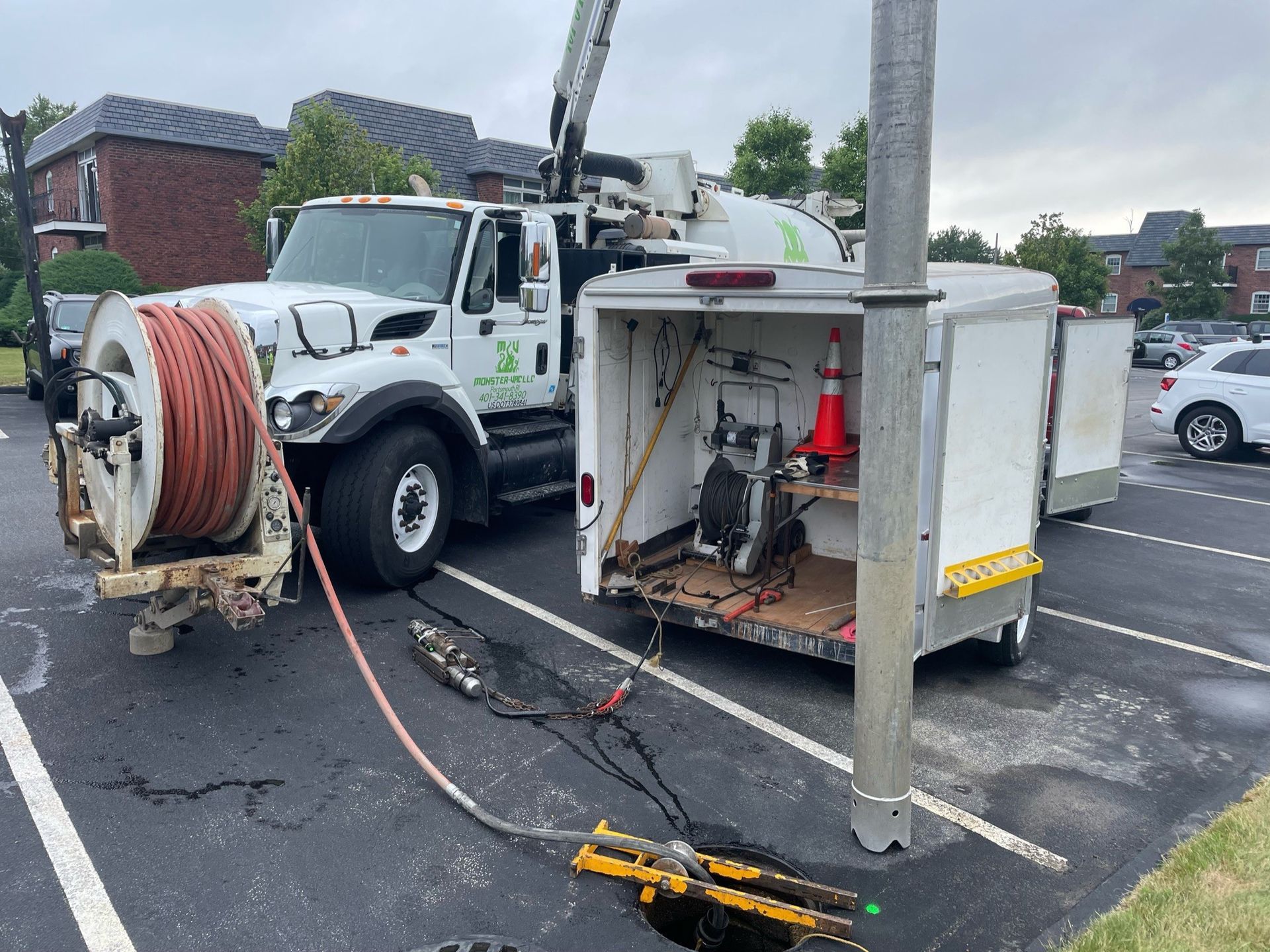 A truck with a hose attached to it is parked in a parking lot.