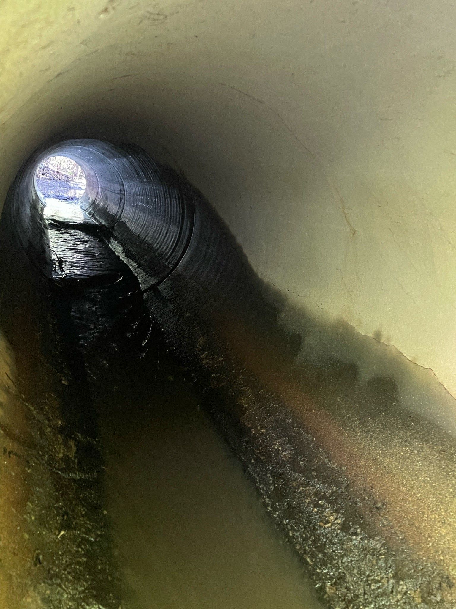 A close up of a pipe in a tunnel filled with water.