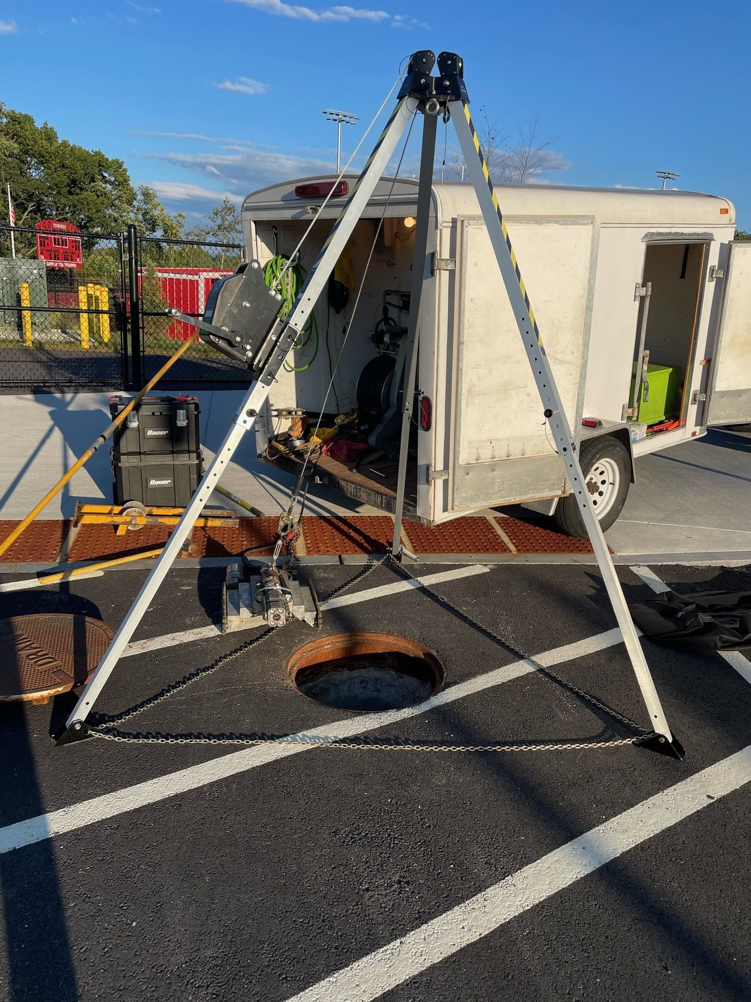 A tripod is sitting in front of a trailer in a parking lot.