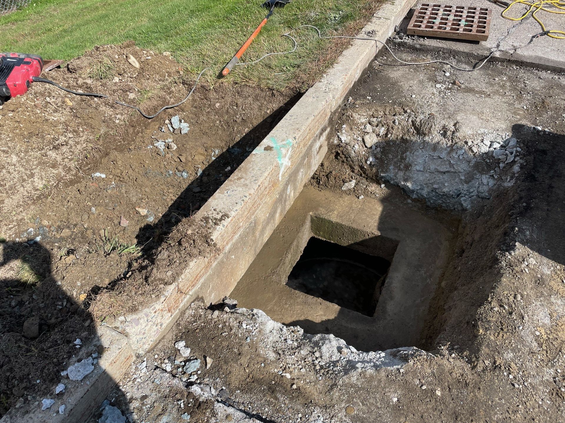 A manhole cover is being installed in a hole in the ground.