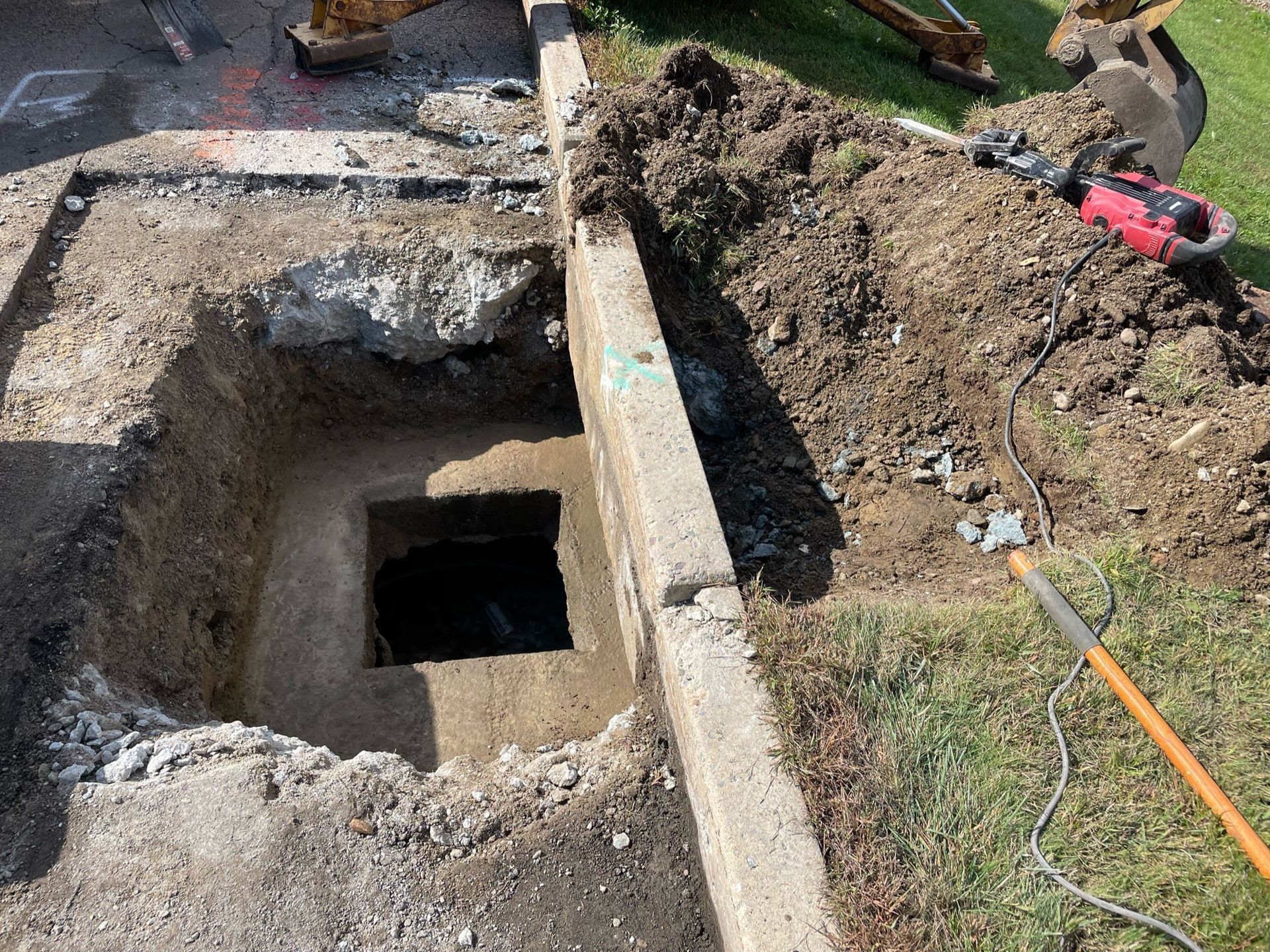 A hole in the ground with a shovel in it.