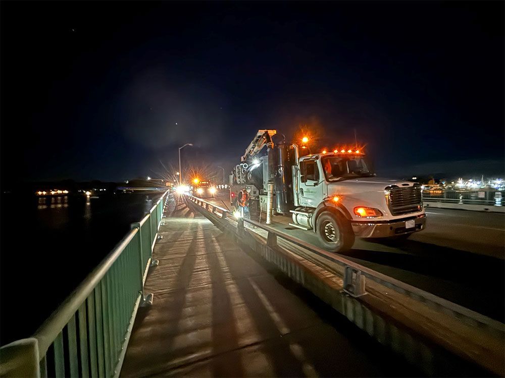 A truck is driving on a bridge at night.