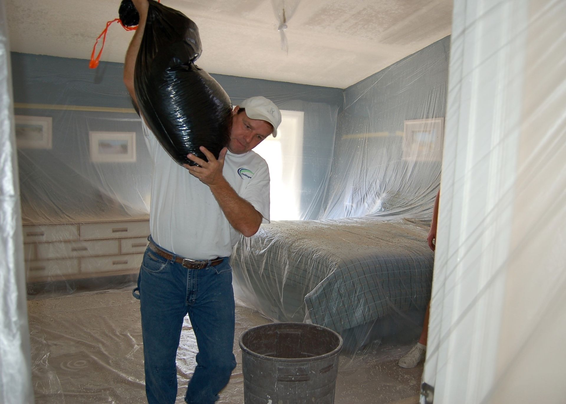 A man is carrying a large black bag over his head