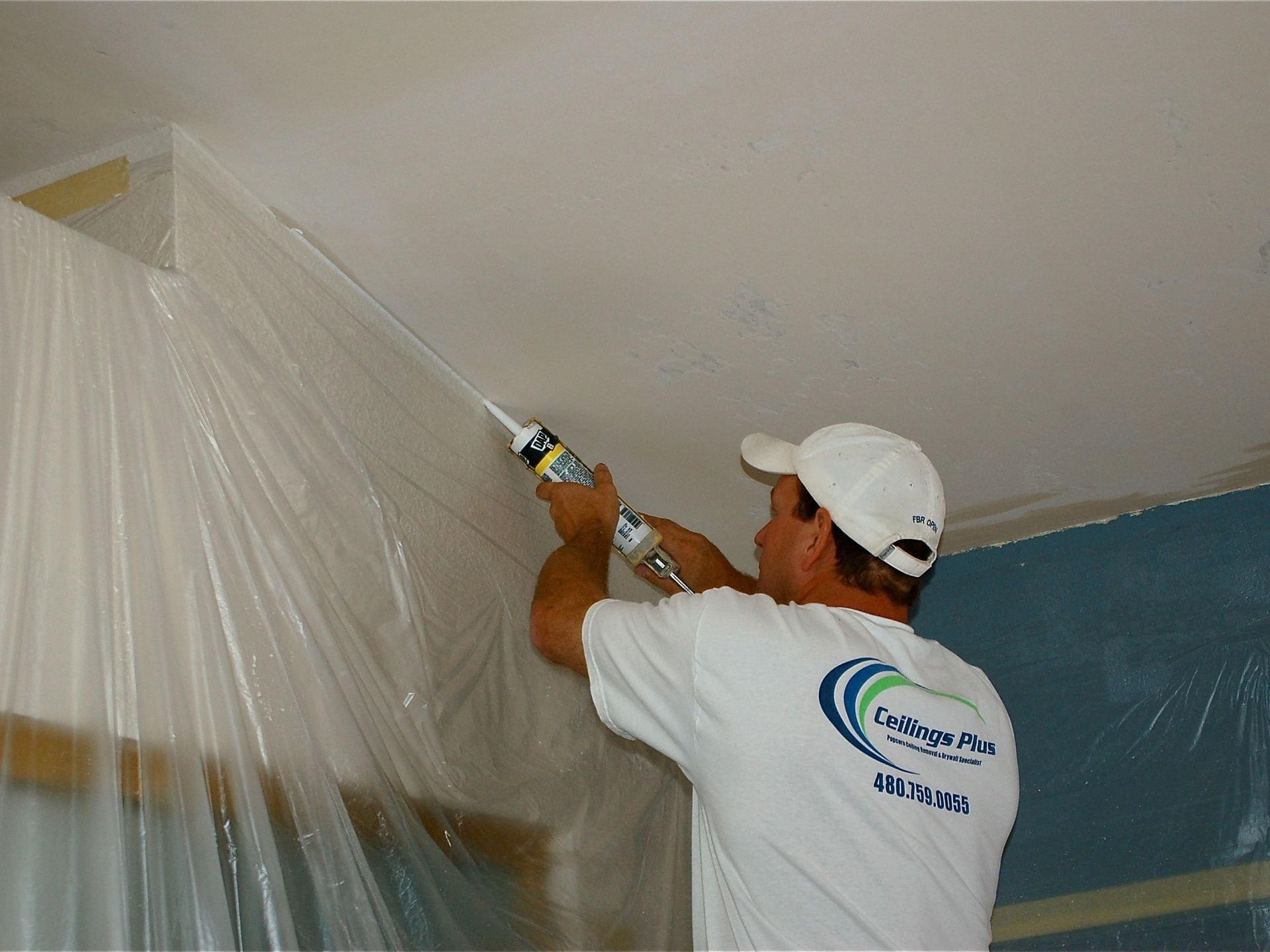 A man wearing a white shirt that says ' painting ' on it
