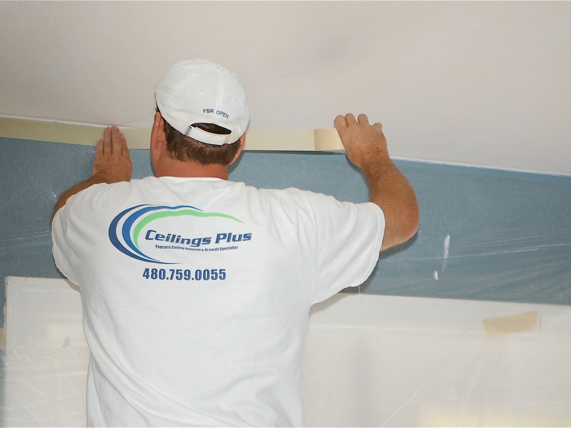 A man wearing a white shirt that says ceilings plus