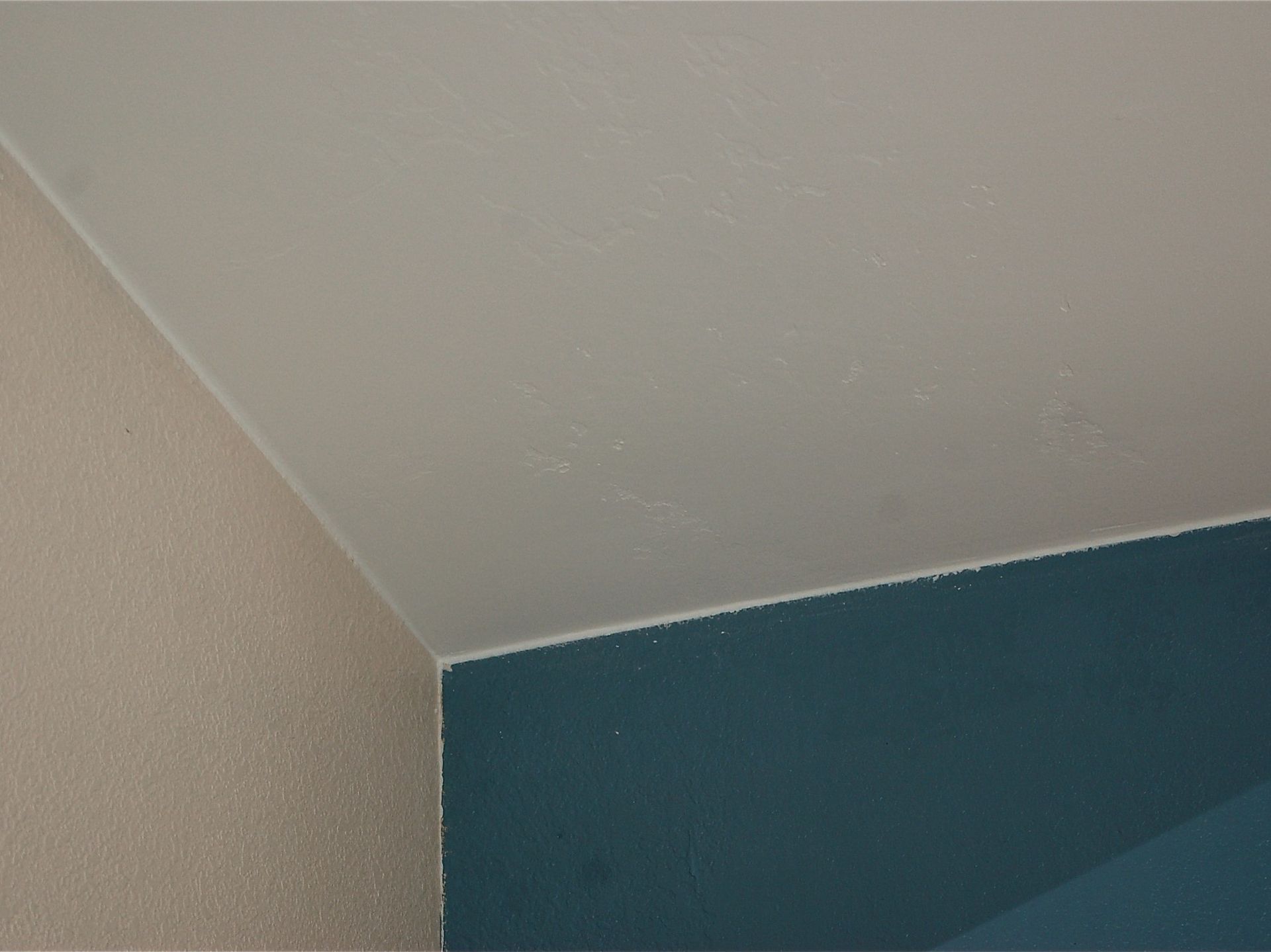 A close up of a white ceiling with a blue corner.