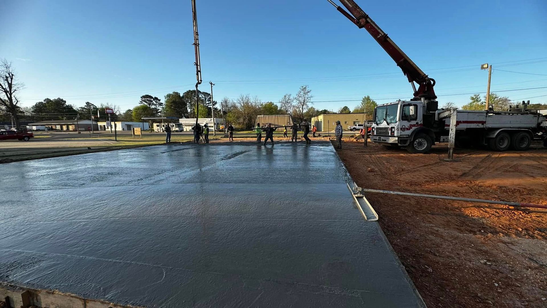 A crane is pumping concrete into a concrete floor.