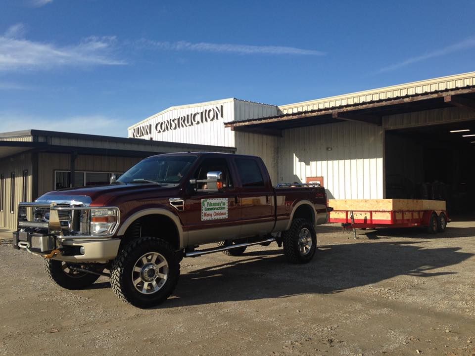 A pickup truck is parked in front of a building that says construction.