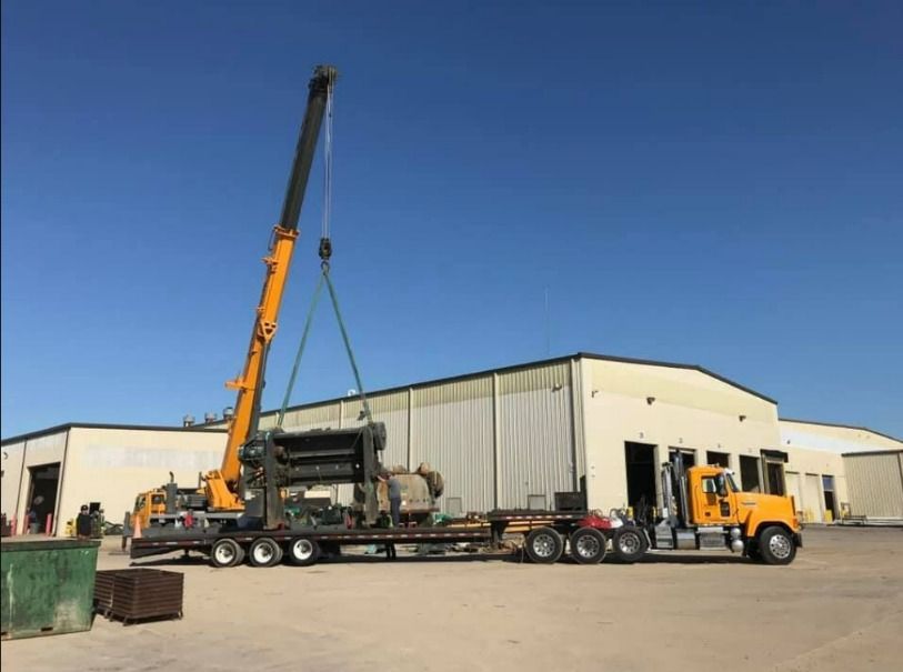 A truck is being lifted by a crane in front of a building.