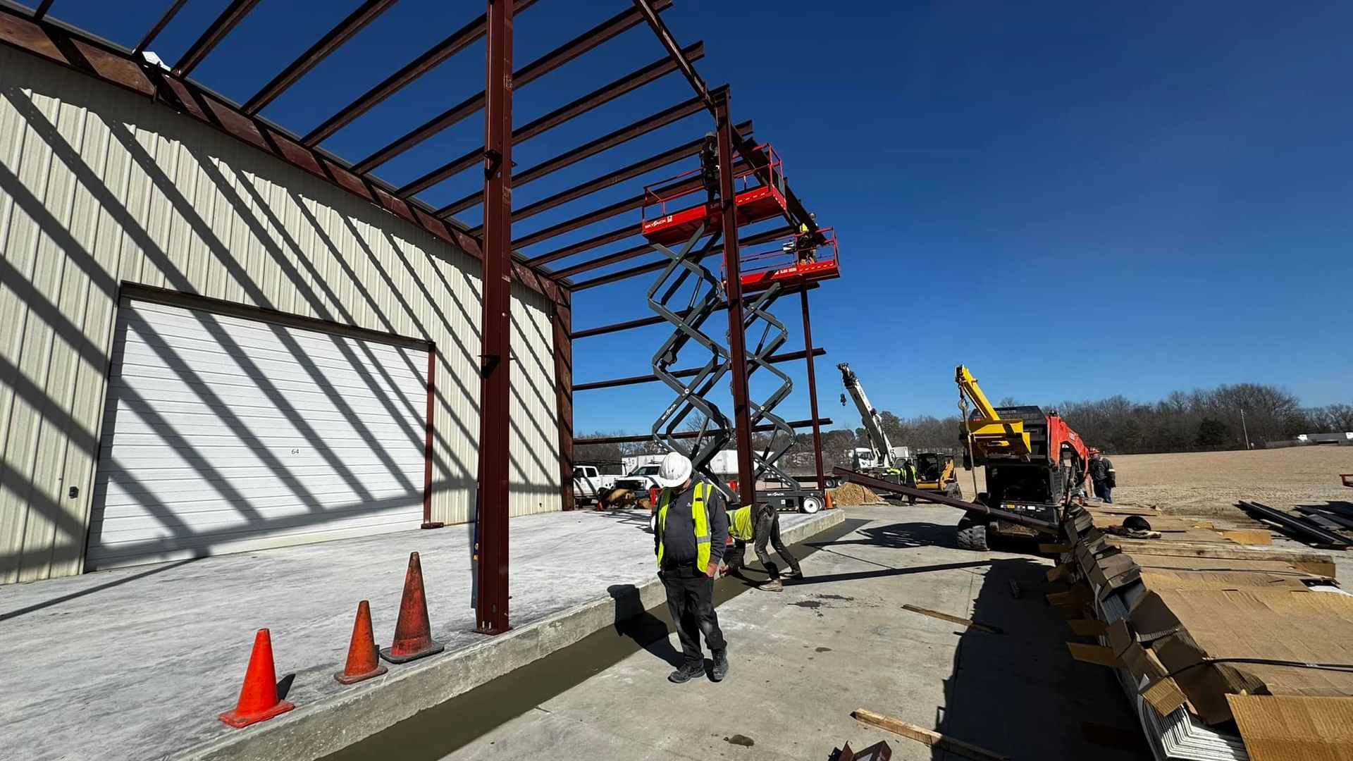 A man is standing in front of a building under construction.