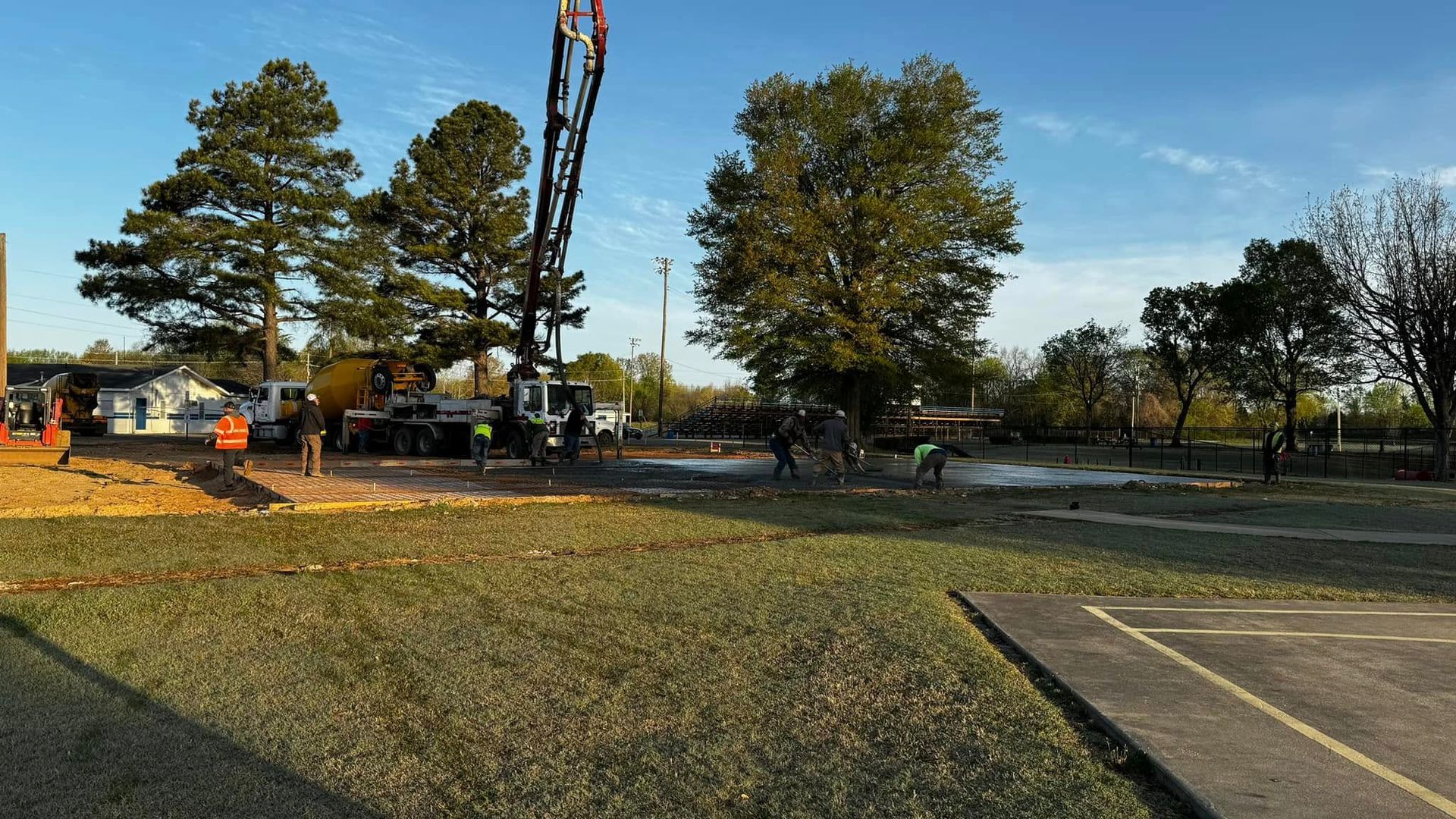 A group of people are working on a construction site in a parking lot.