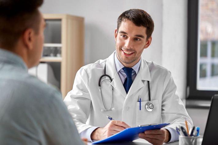 A doctor is talking to a patient while holding a clipboard.