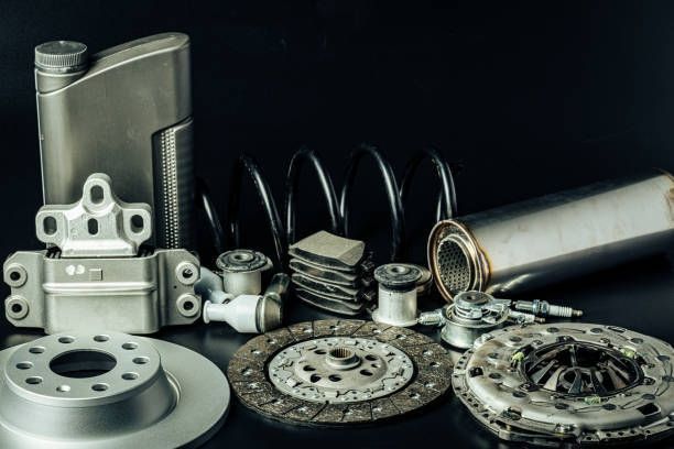 Car parts laid out, including brake rotors, clutch discs, and a spring.